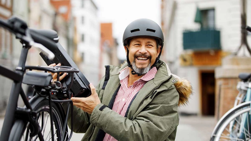 Ein lachender Mann neben seinem S-Pedelec Ein lachender Mann neben seinem S-Pedelec